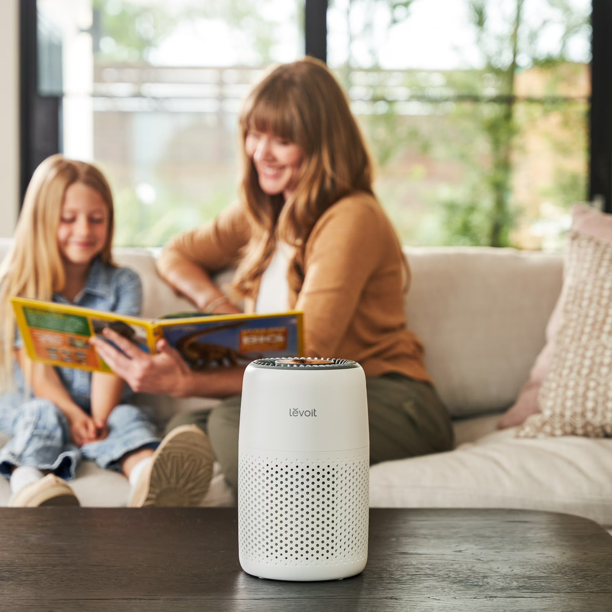 Core Mini air purifier beside a family reading on a sofa